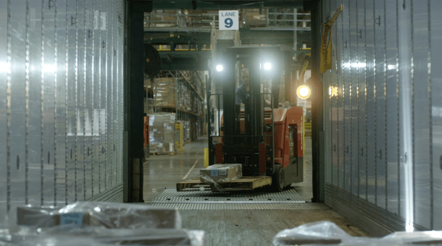 A forklift transporting goods in a warehouse.