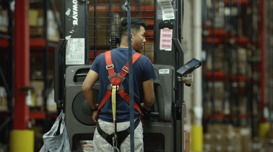 A man operating a forklift in a warehouse.