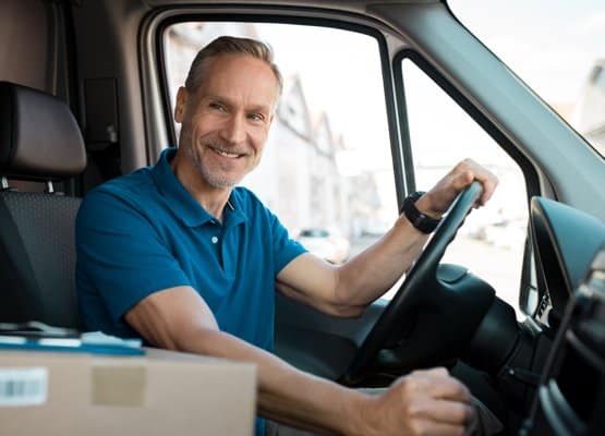 a truck driver sitting in driver seat smiling