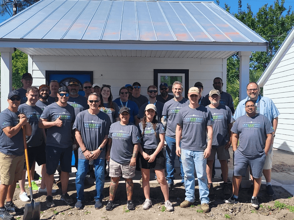 Legacy Supply Chain team stands in front of tiny home built in Glynn County