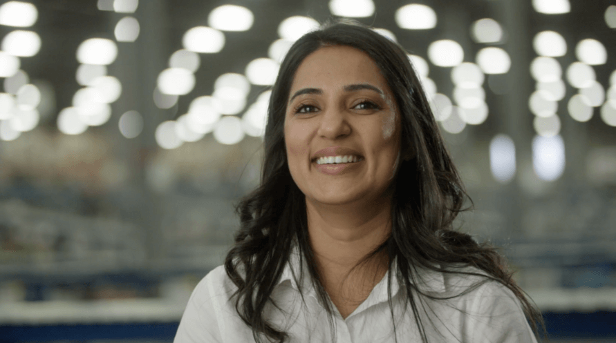 A woman in a white shirt smiling at the camera.