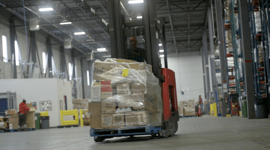 A forklift transporting goods in a warehouse.