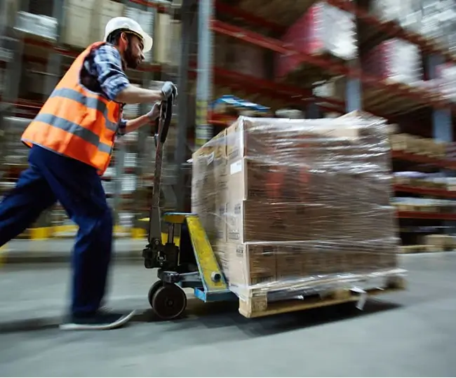 Man pushing boxes in warehouse