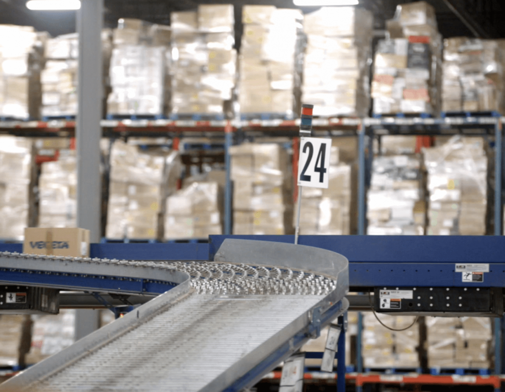 Conveyor belt in warehouse with boxes, ready for shipping.