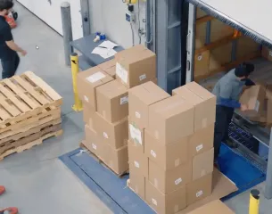 Men loading a semi truck with cardboard boxes.