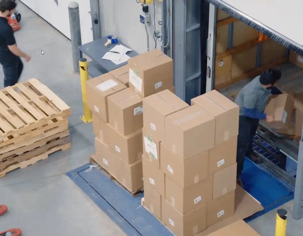Men loading a semi truck with cardboard boxes.