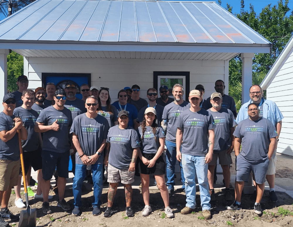 Legacy Supply Chain team stands in front of tiny home built in Glynn County