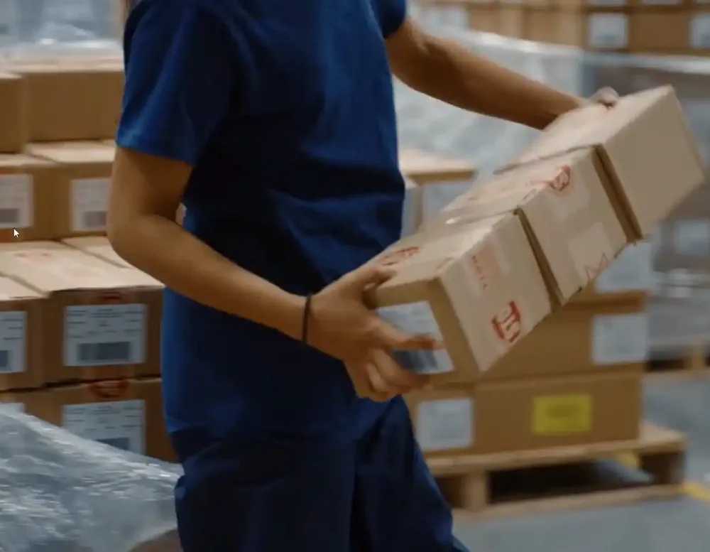 A worker holding a long cardboard box.
